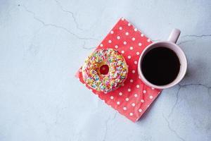 Vista superior de donas y taza de café en la mesa foto