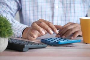 Close up of man hand using calculator photo