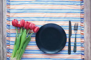 cutlery and empty plate on wooden background top down photo