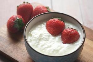 fresh strawberry and yogurt in a bowl on table photo