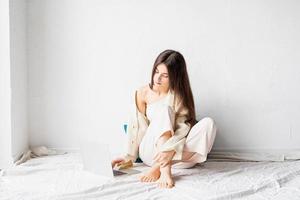 woman sitting on the floor and doing freelance project on laptop photo