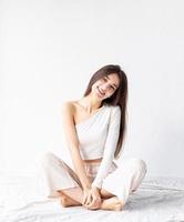 young woman in white cozy clothes sitting on the floor