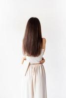 woman on white background holding a book, view from behind photo