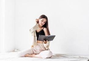 woman in comfy home clothes writing notes sitting on the floor photo