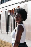 happy African American woman walks down the street in the summer photo