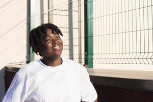 Retrato de una mujer afroamericana feliz en la calle en verano foto