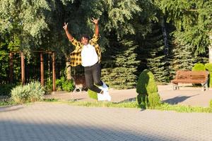 a happy African American woman in the park makes a jump in the summer photo