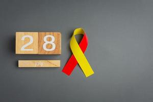 World hepatitis day awareness with red yellow ribbon photo