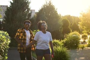 two happy African-American women are walking down the street photo