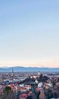 Horizonte panorámico de Turín al atardecer con los Alpes en segundo plano. foto