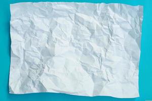 Abstract white crumpled paper texture on blue sky background photo