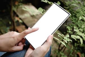 mano de mujer sosteniendo teléfono inteligente con pantalla en blanco foto