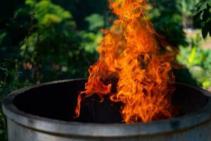 Cement tank at fire flames on blurred background photo