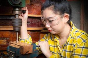 Women standing is craft working drill wood photo
