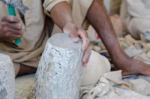 hands of a male Egyptian sculptor while working with a stone alabaster photo