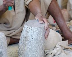 hands of a male Egyptian sculptor while working with a stone alabaster photo