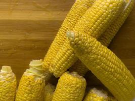 Grains of ripe corn on wooden background. photo