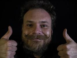 funny face of a man with a beard and mustache and showing thumbs up photo