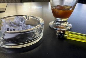 Coffee with ice, lighter and ashtray photo