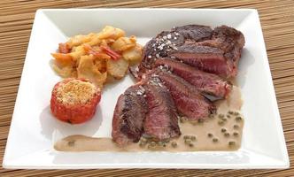 Plate of beef entrecote with tomato and potatoes photo