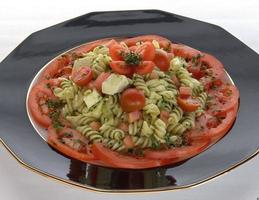 Pasta salad with tomatoes, basil and mozzarella photo