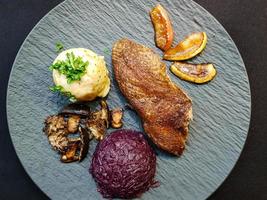 pato al horno con col lombarda y setas del bosque foto