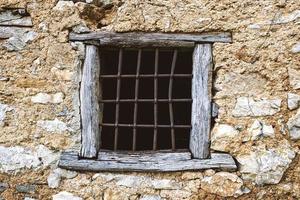 Ancient window attached to a historic stone house photo