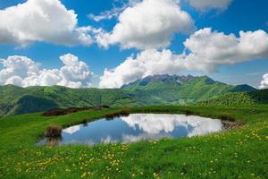 pequeño lago alpino en medio de la pradera foto