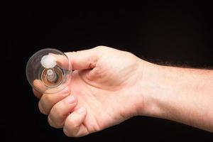 Light bulb in hand on a black background photo