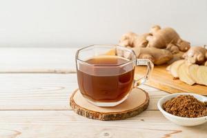 Hot and sweet ginger juice glass with ginger roots - Healthy drink style photo