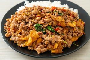 Stir-fried minced pork with basil and egg topped on rice - Asian food style photo