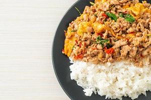Stir-fried minced pork with basil and egg topped on rice - Asian food style photo