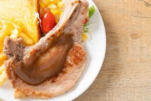 Pork chop steak with chips and mini salad on white plate photo