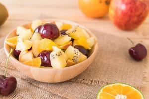 Fruta en rodajas mixtas en un tazón de madera foto