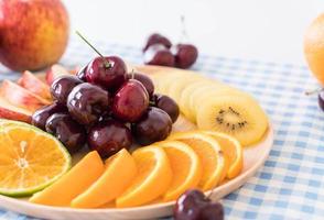 Mixed sliced fruit in wood bowl photo