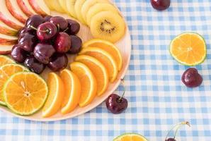 Fruta en rodajas mixtas en un tazón de madera foto