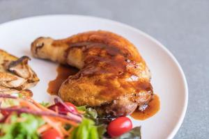 Grilled chicken steak with teriyaki sauce on dining table photo