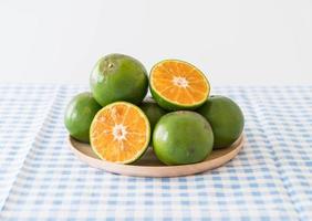 Fresh orange on wood plate on the table photo