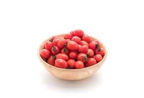 Fresh tomatoes in wood bowl on white background photo