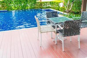 Chair around beautiful luxury swimming pool in hotel resort - boost color up processing style photo