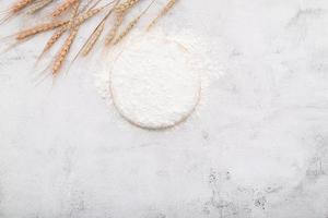 Wheat flour  in wooden bowl set up on white concrete background photo