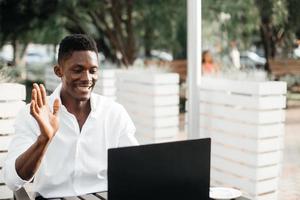 African-American businessman, works at a laptop in a cafe, freelancer photo