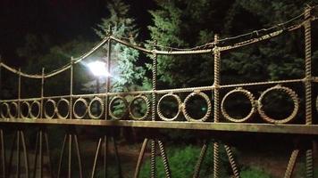 Metal fence at night. Artificial light rays penetrate through photo