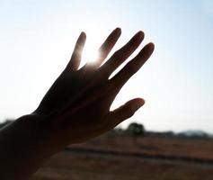 silueta de mano con puesta de sol foto