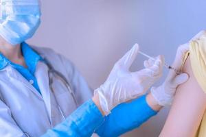 Médico sosteniendo una jeringa con vacuna covid-19 para inyectar al paciente foto