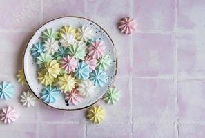 pequeños merengues de colores en el plato de cerámica foto