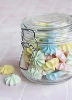 Small colorful meringues in the glass jar photo