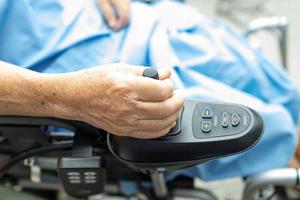 Asian senior woman patient on electric wheelchair with remote control photo