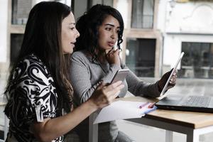 mujeres de negocios que trabajan con sus computadoras portátiles en una oficina foto
