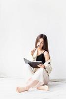 woman in comfy home clothes writing notes sitting on the floor photo